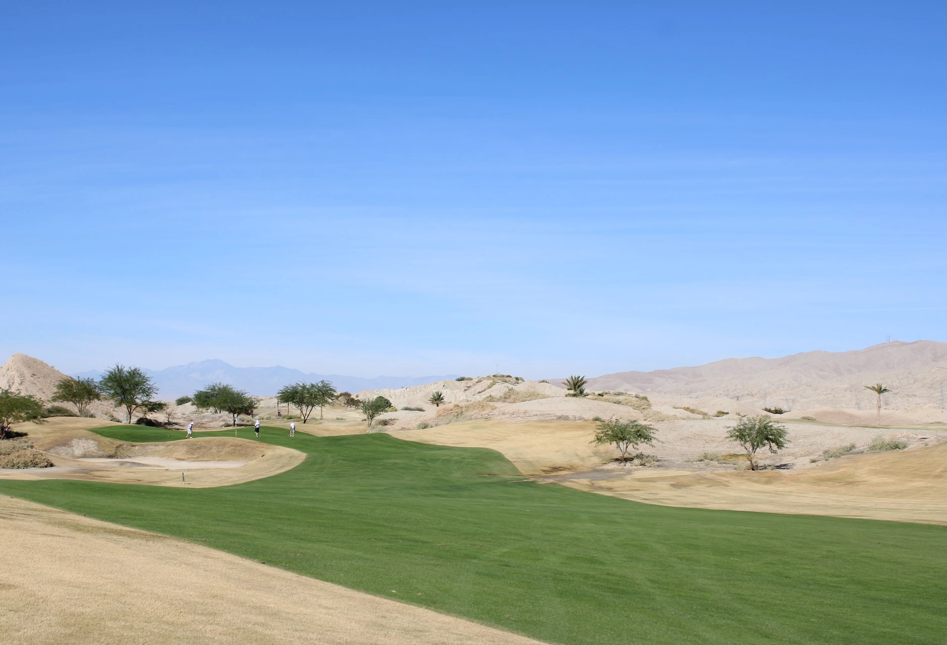 a golf course with sand dunes and trees