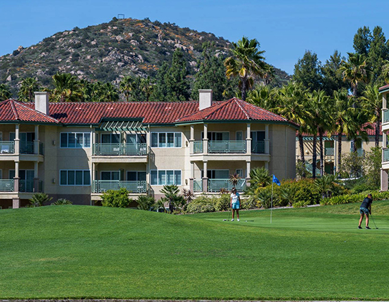 two women putting on the green