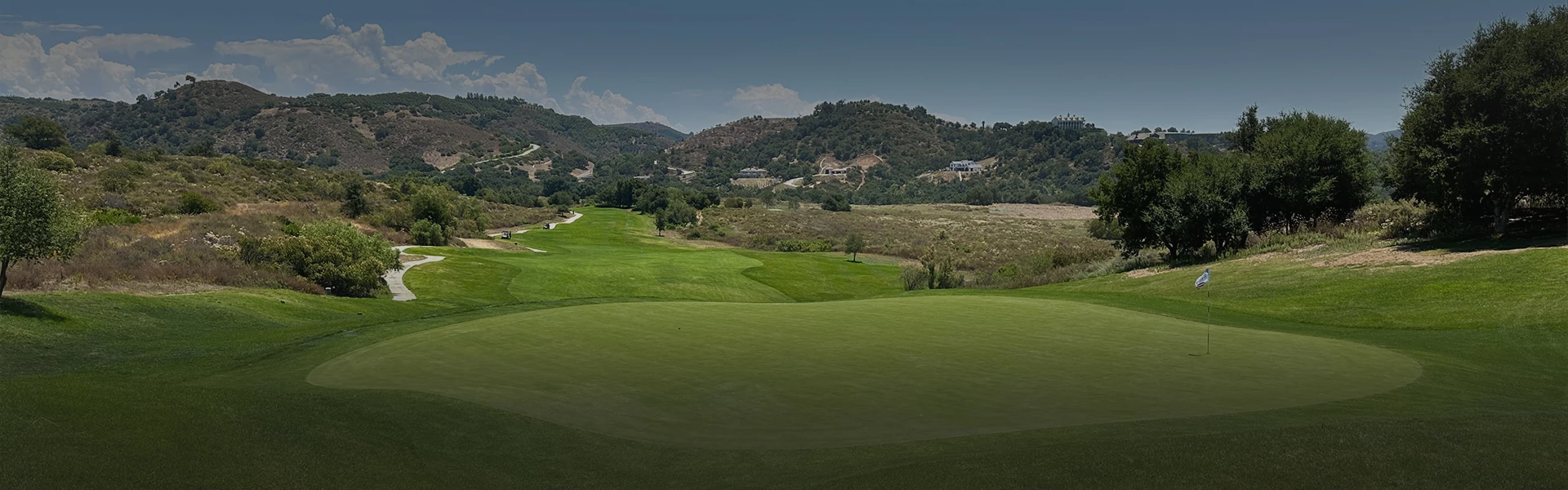 a golf course with hills in the background
