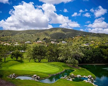 mountains and homes located just beyond the golf course and the sun shining 