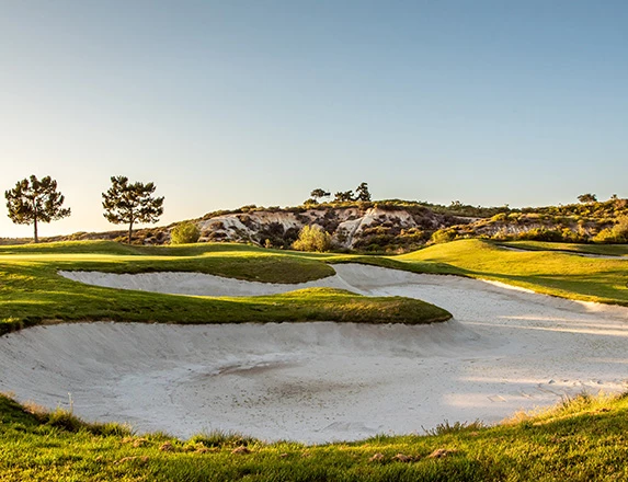 the sun shining over a golf course with clear blue skies