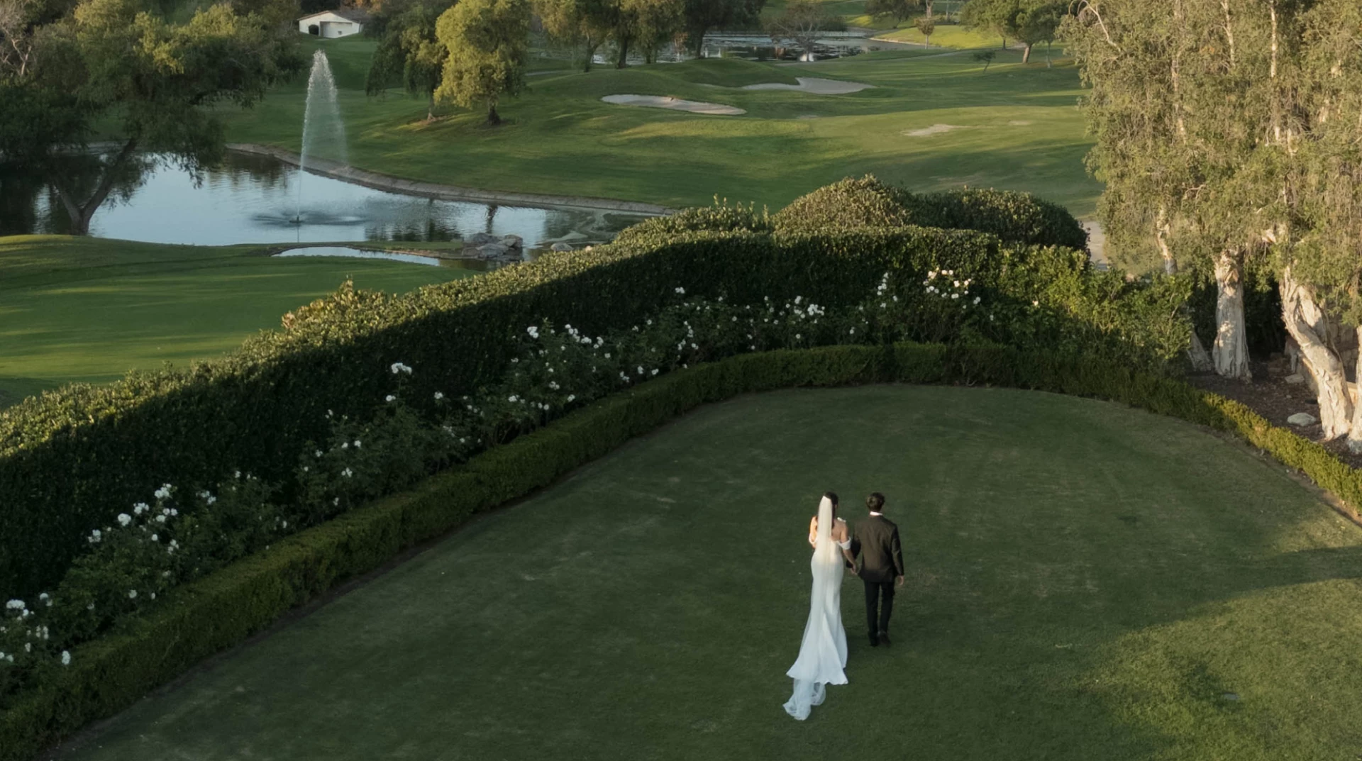 a man and woman walking on a golf course