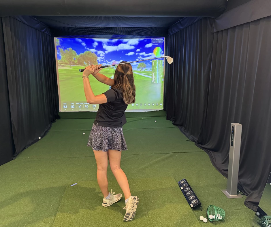 a woman playing golf in a room
