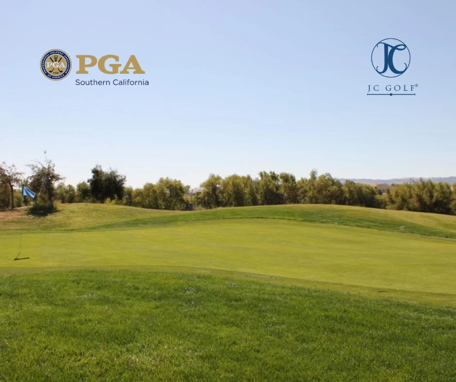 a golf course with trees and blue sky