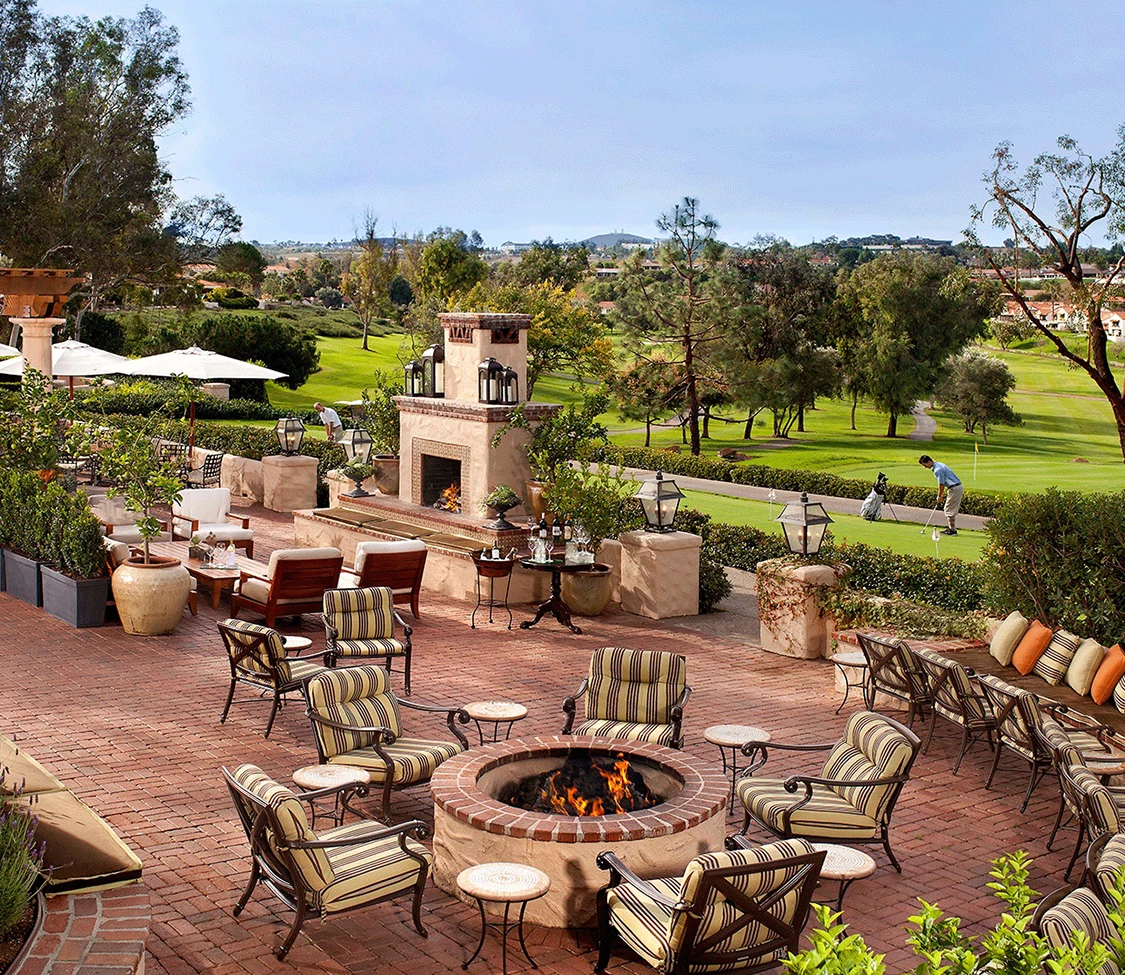 a patio with chairs and a fire pit