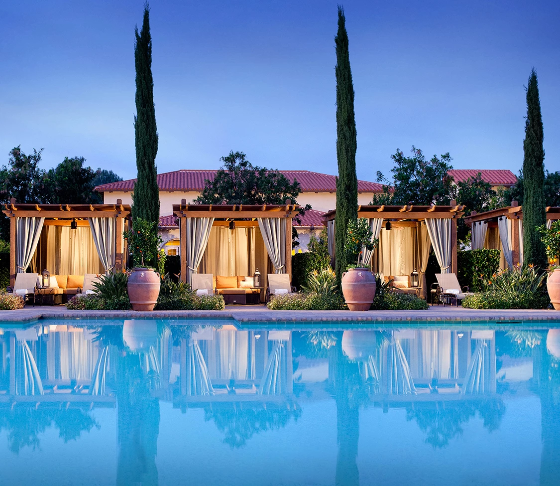 a pool with a row of gazebos and trees