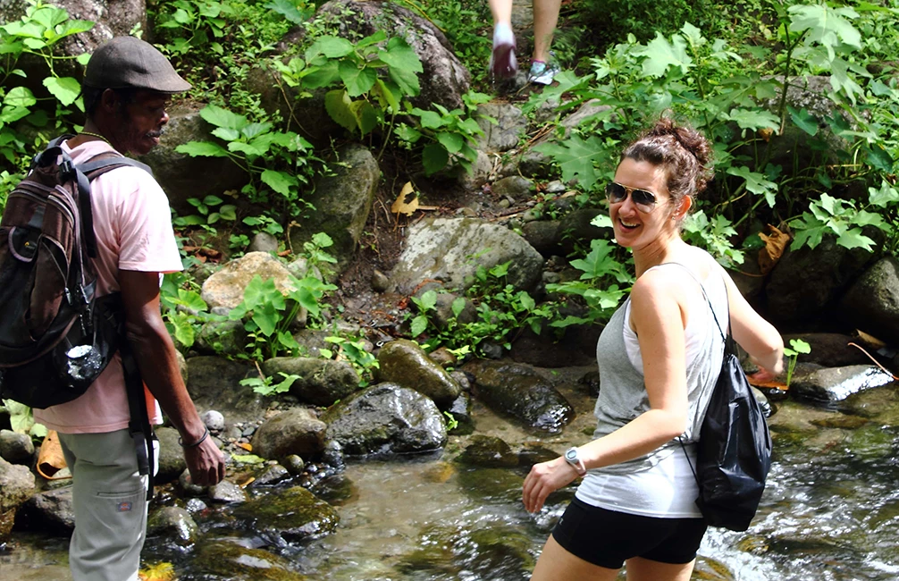man and woman walking through a river
