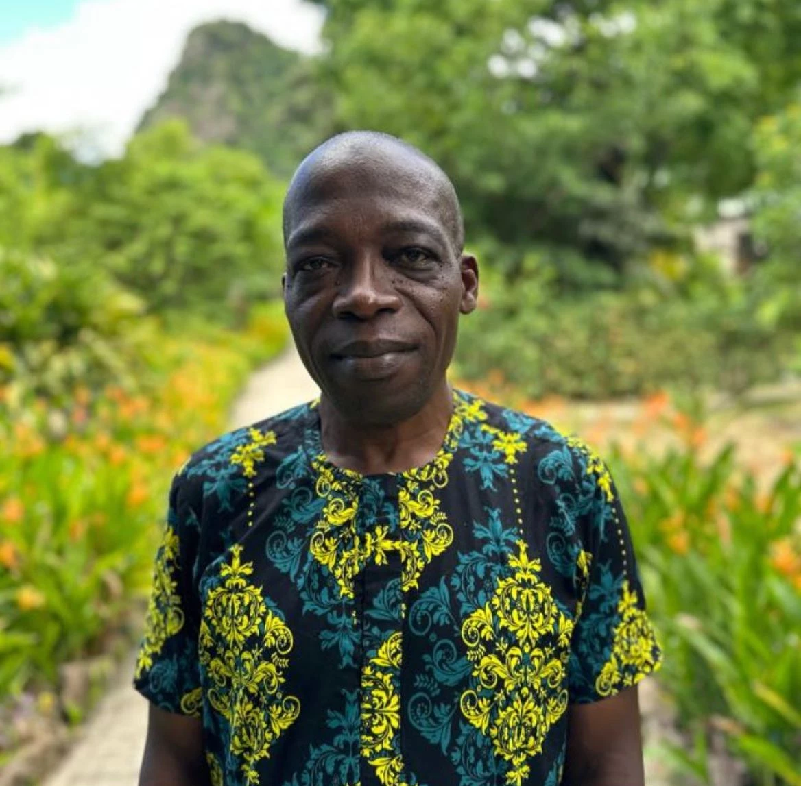 a man standing outside in a garden
