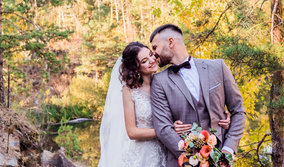 a man kissing his fiance and holding the bouquet