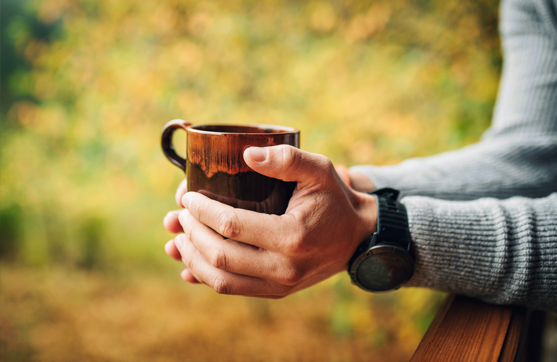 view of a person holding a cup of coffee