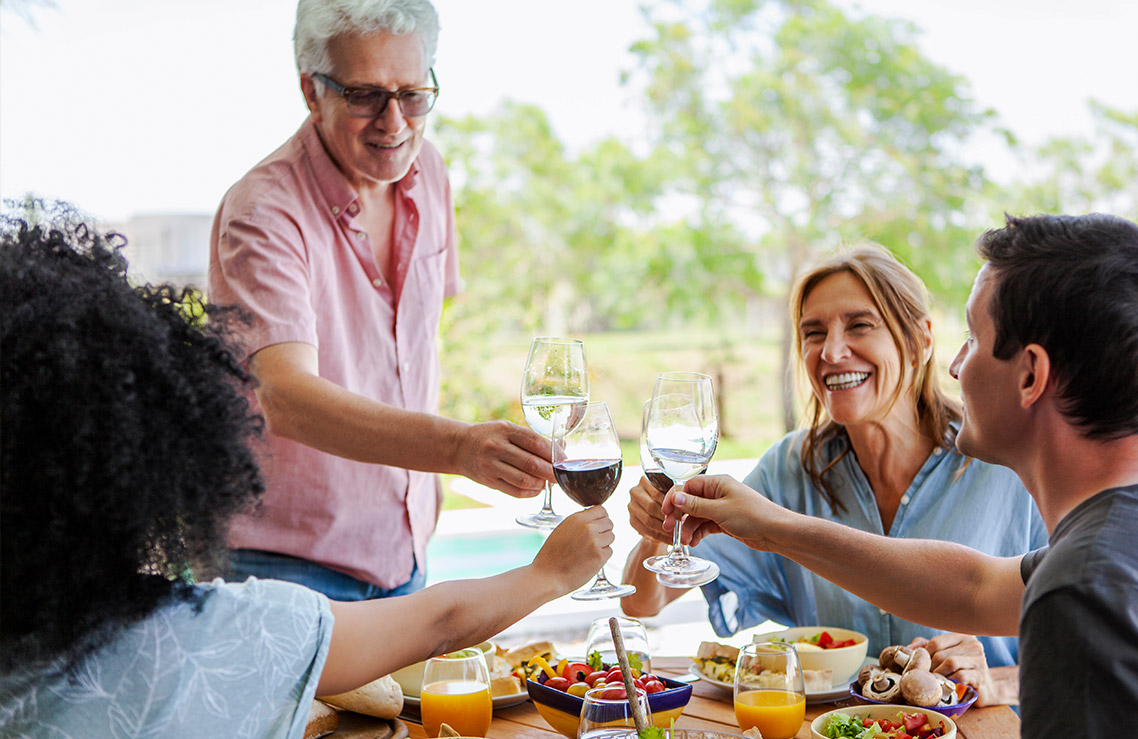 four people cheering with wine glasses 