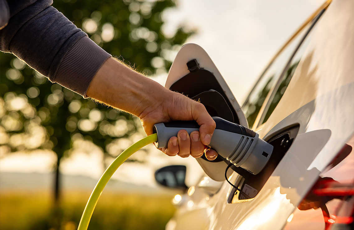 person fulling their electric car