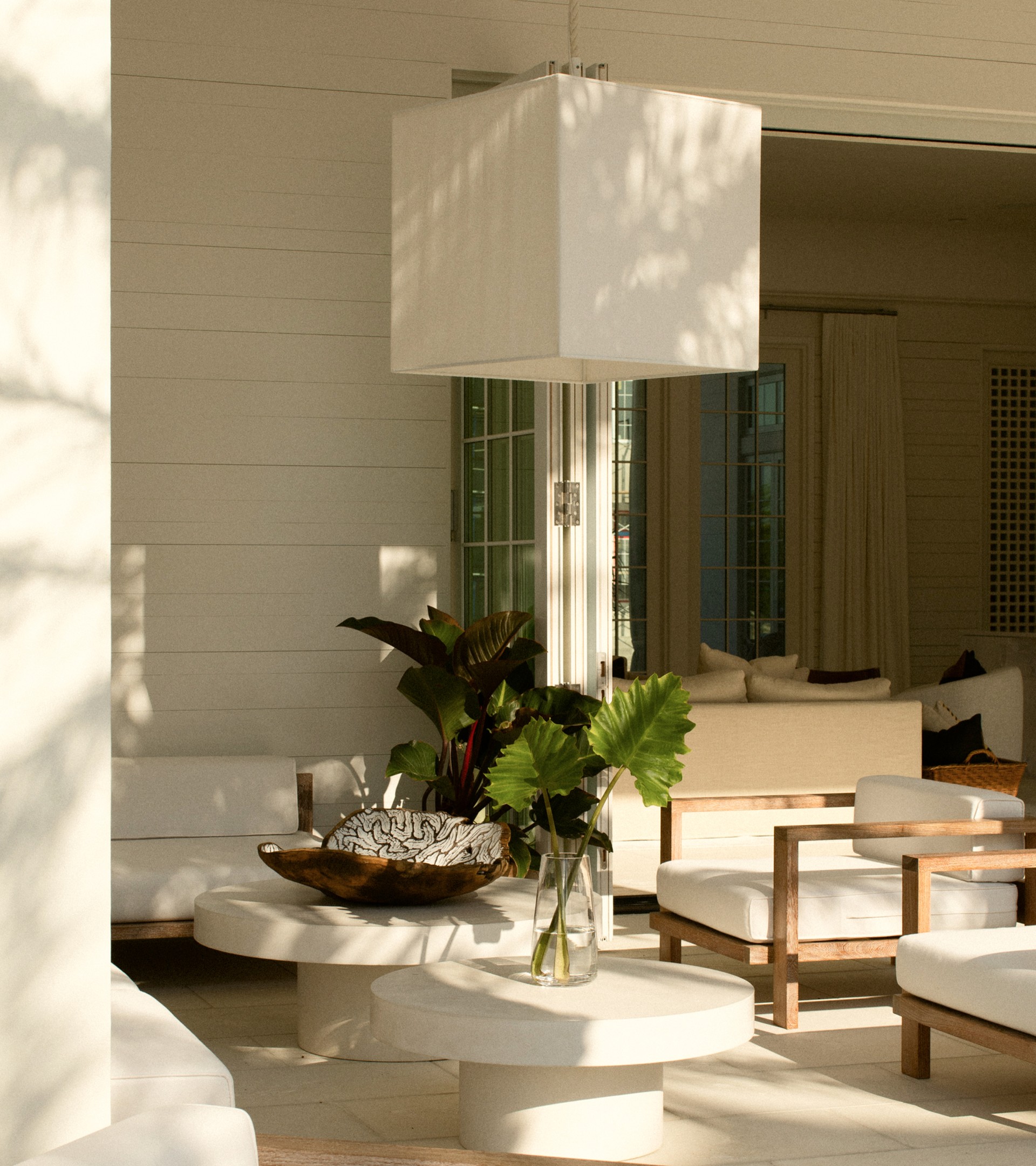 a white room with a white lamp and a white table