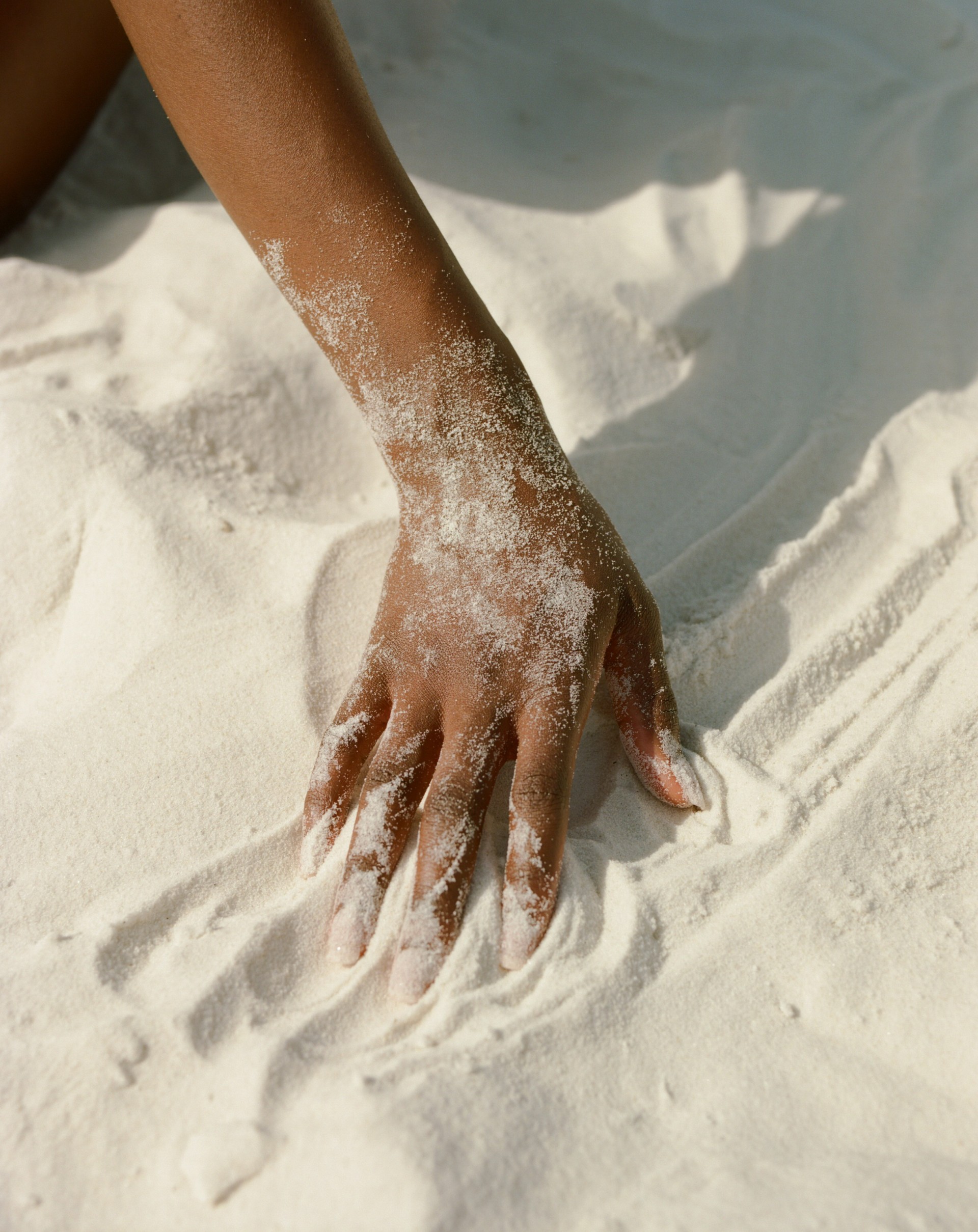 a hand on a white sand