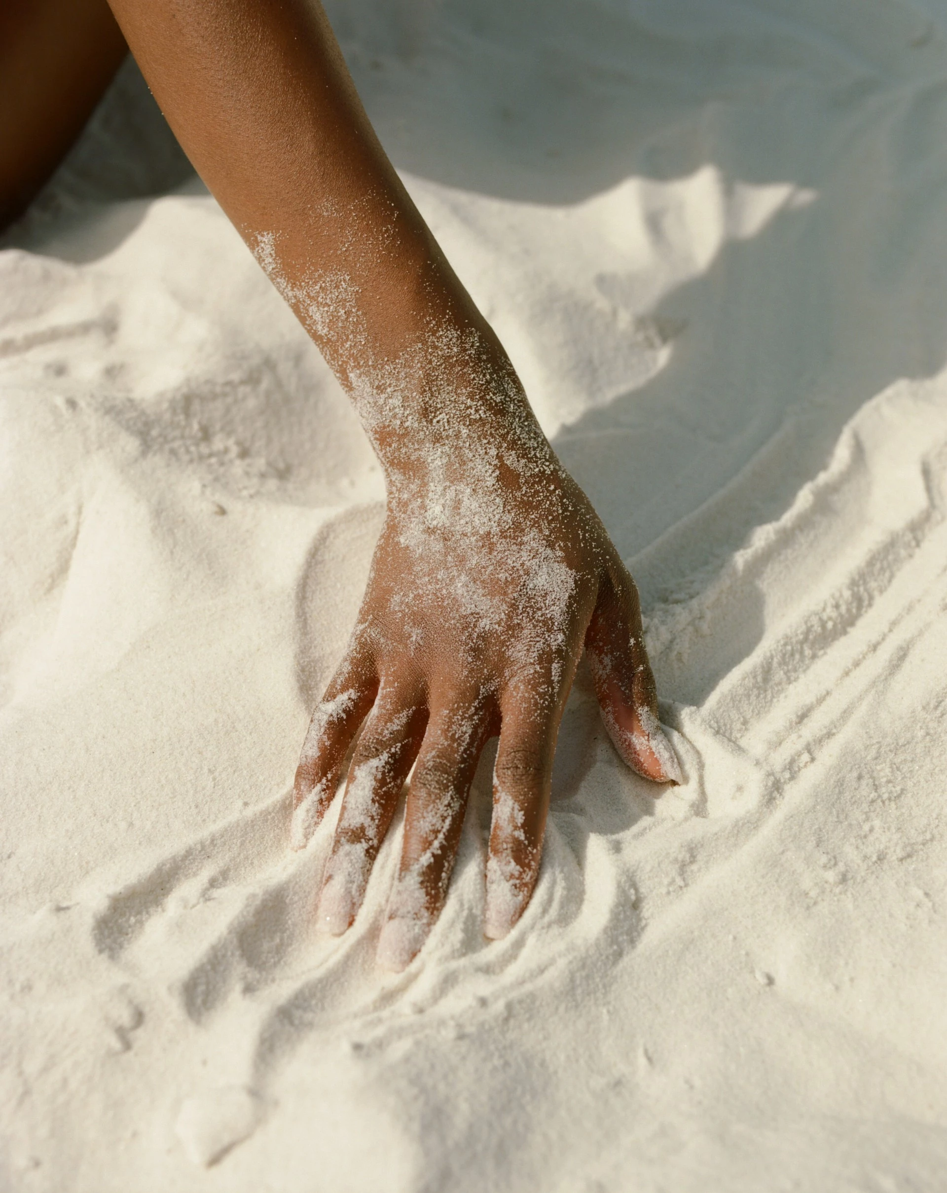 a hand on a white sand