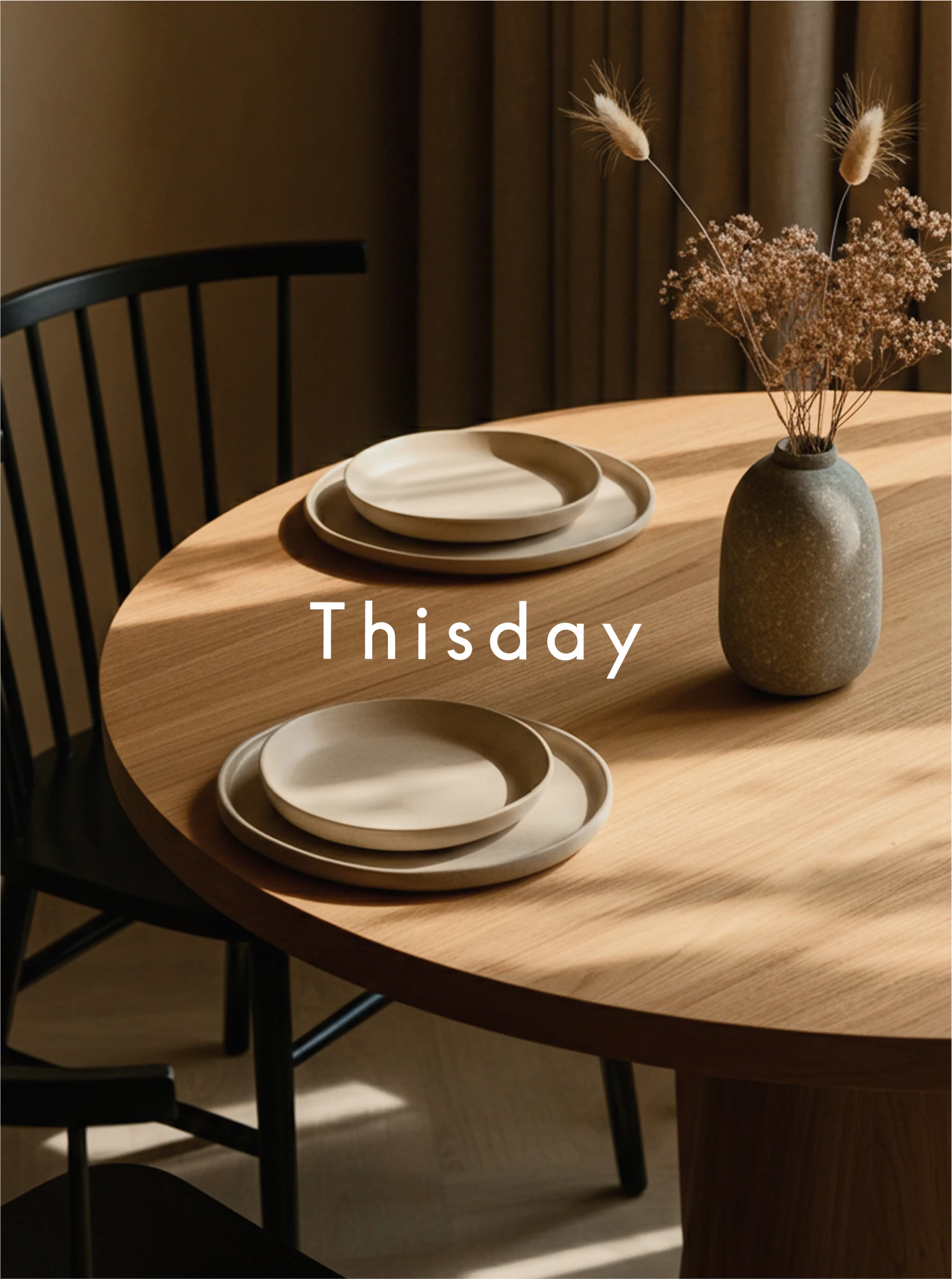 a table with plates and a vase of flowers