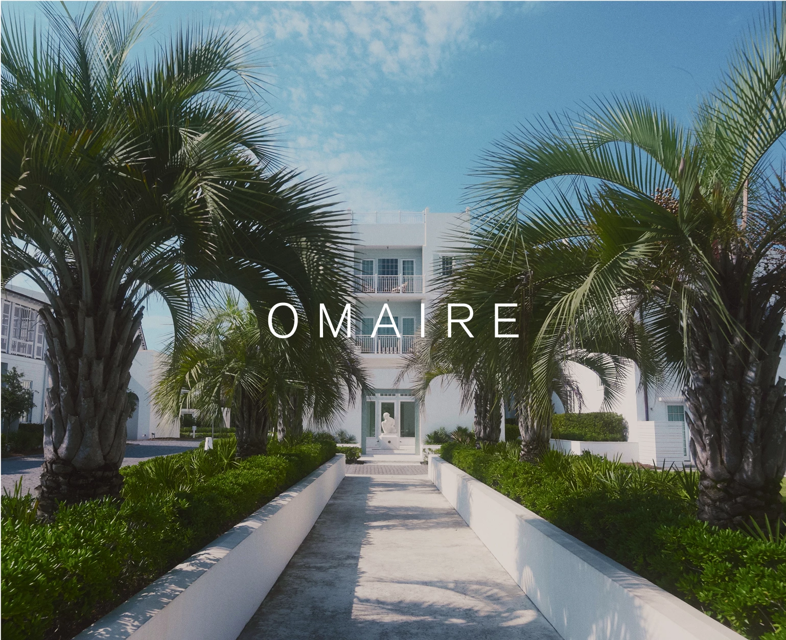 a white building with palm trees and a white door