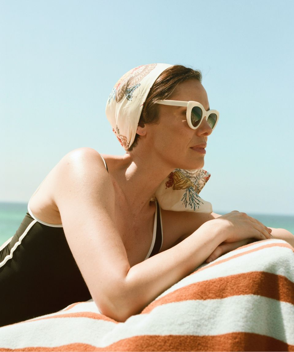 a woman in a bathing suit and sunglasses