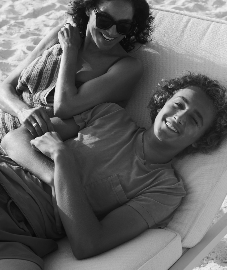 a man and woman lying on a beach chair