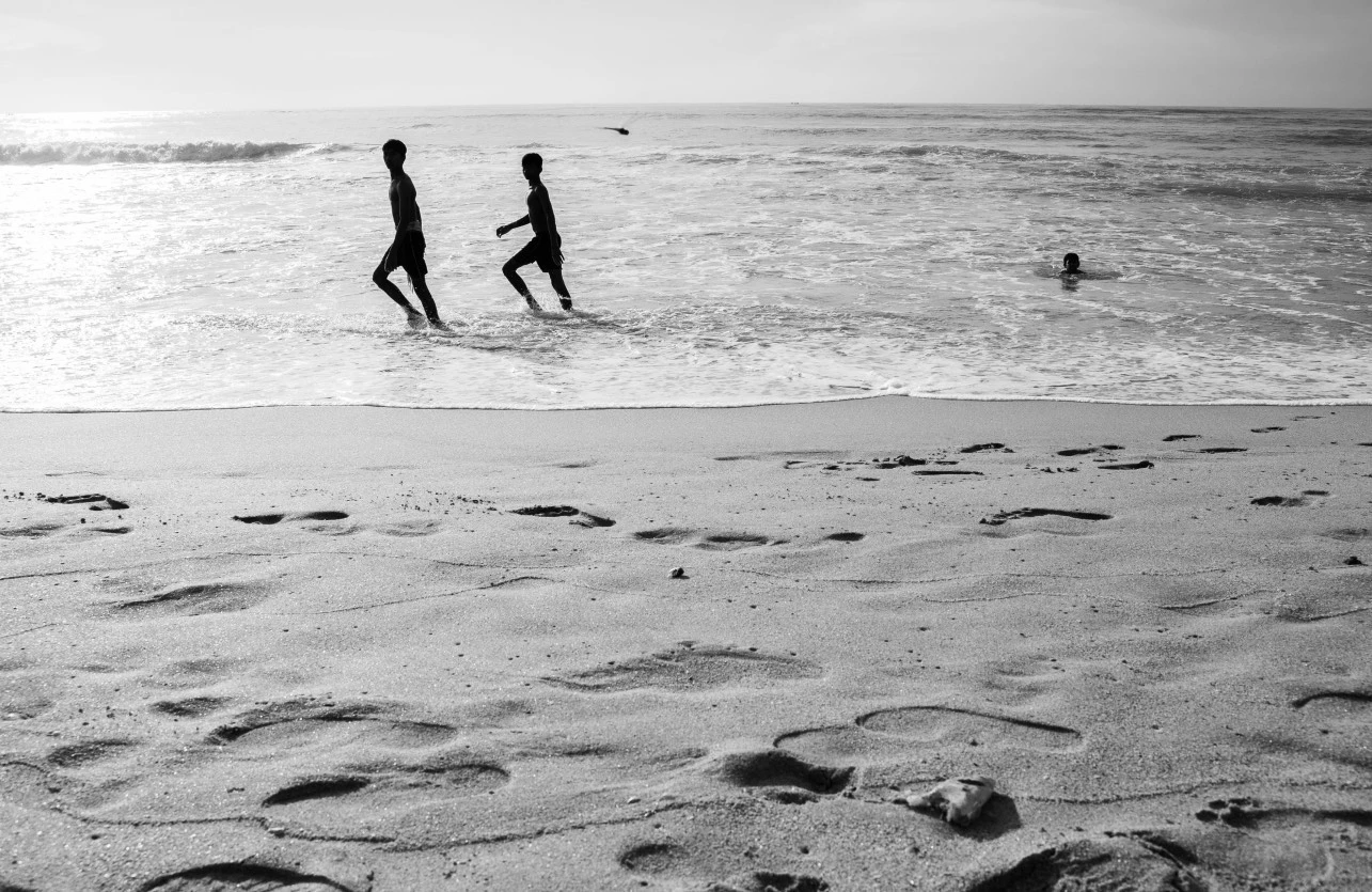 a group of kids running in the water