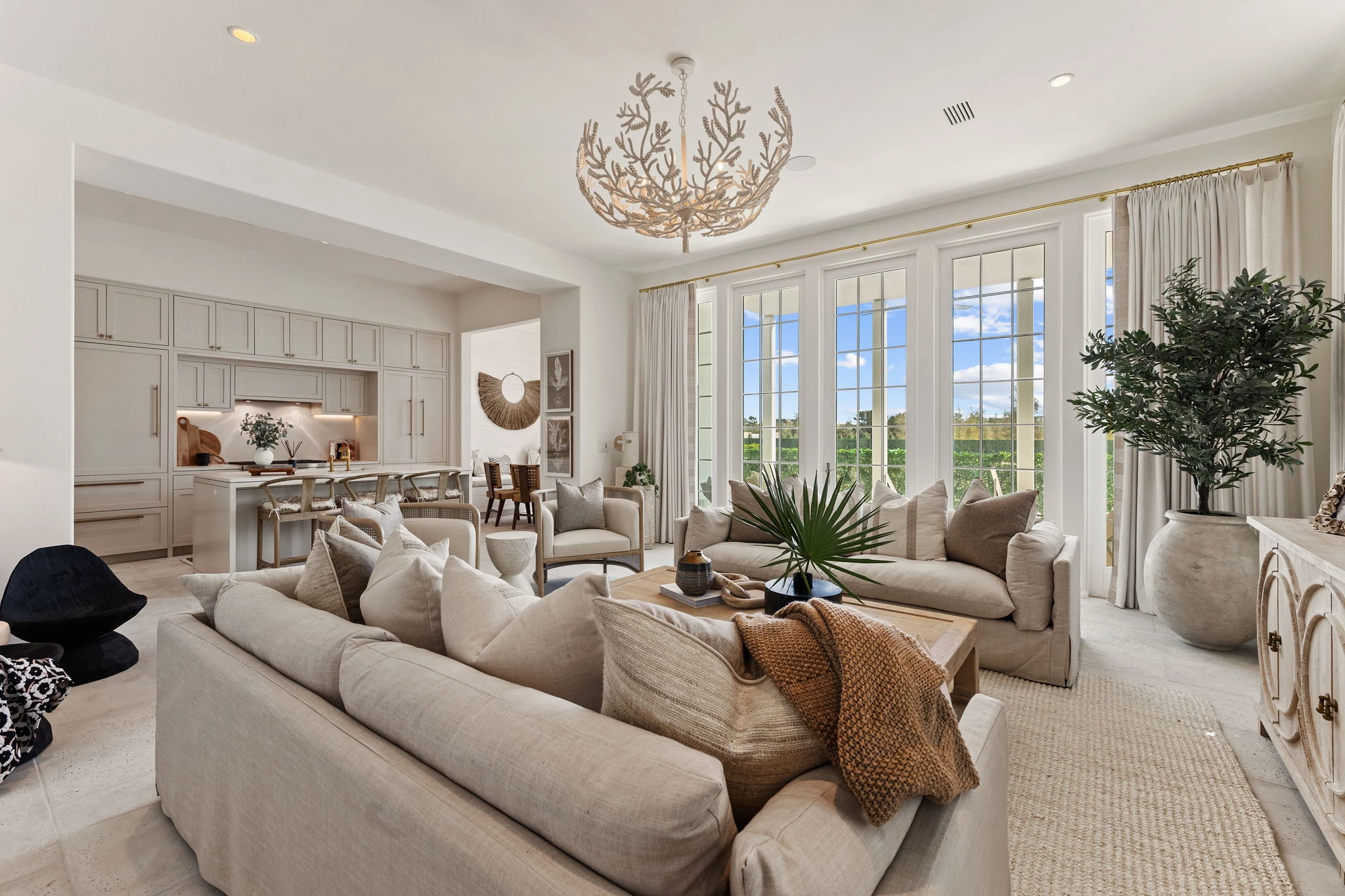 a living room with a large chandelier and couches