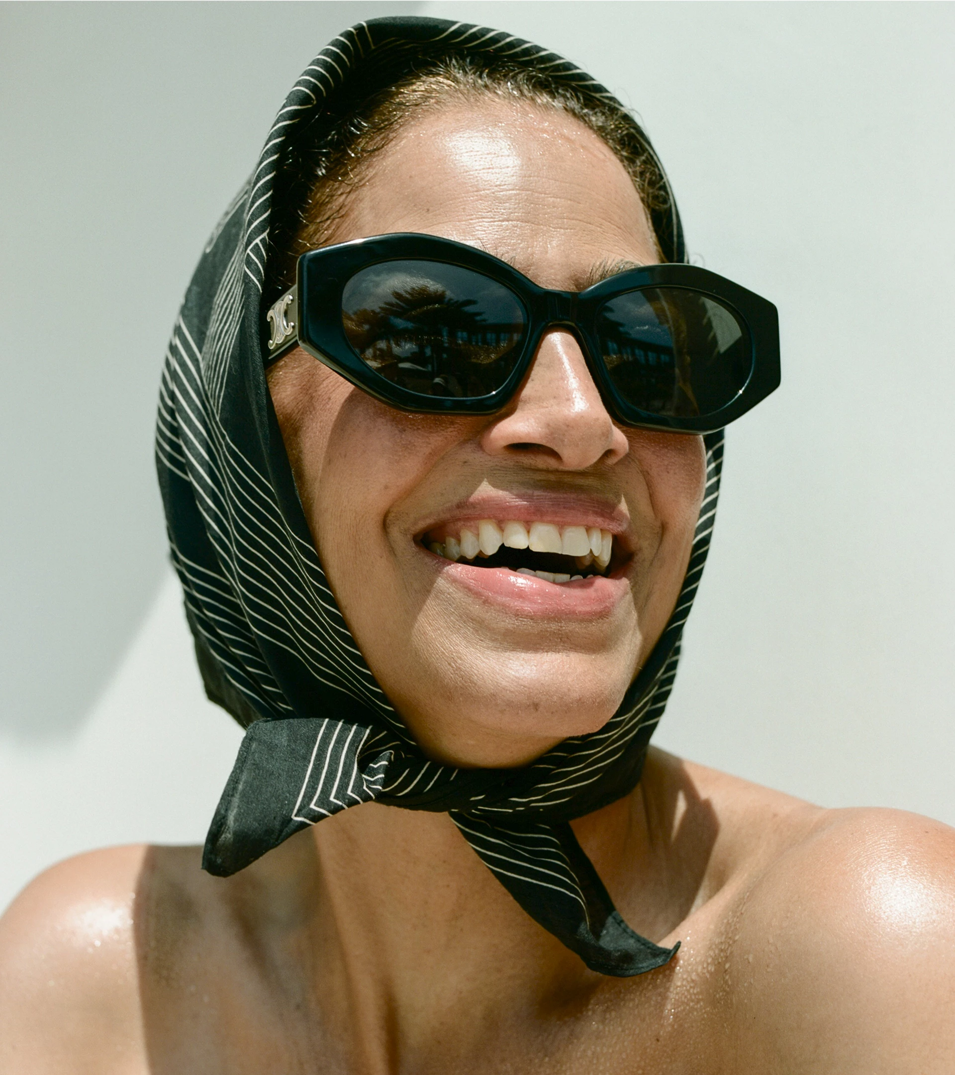 a woman wearing sunglasses and a scarf on her head
