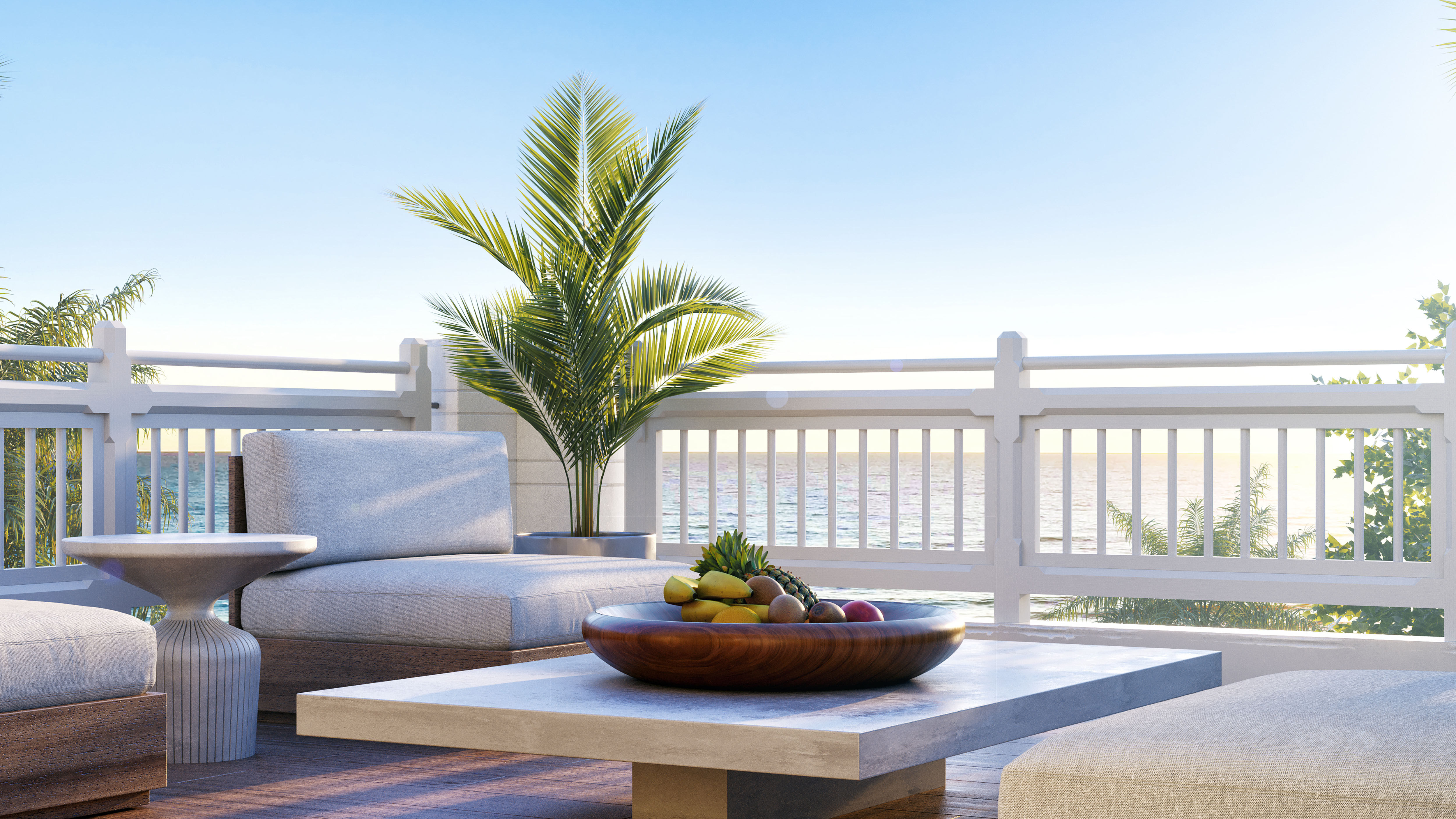 a table with fruit on it and a palm tree in front of the water
