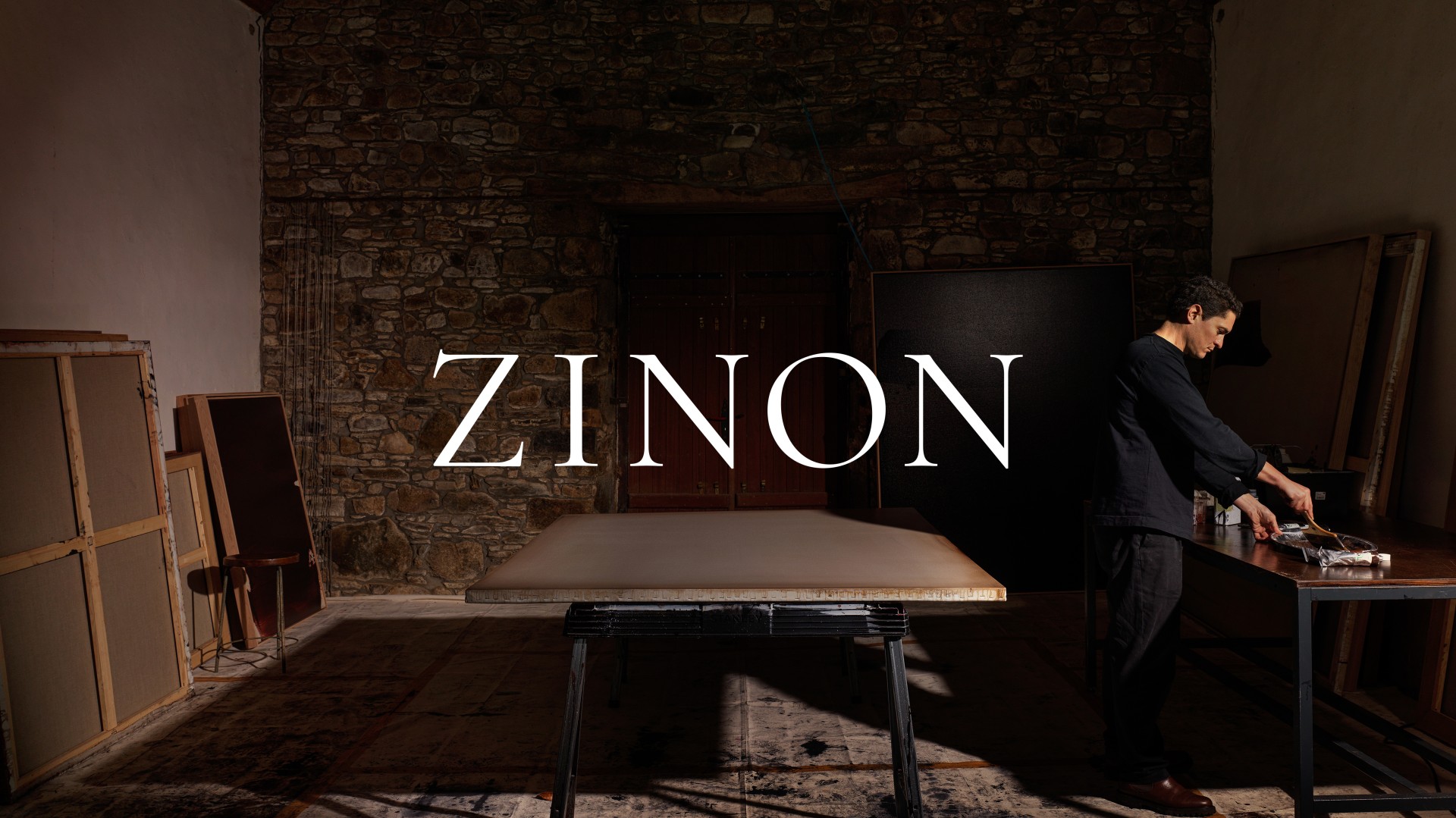 an artist standing in front of a table