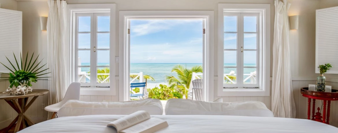 a bed with white sheets and pillows