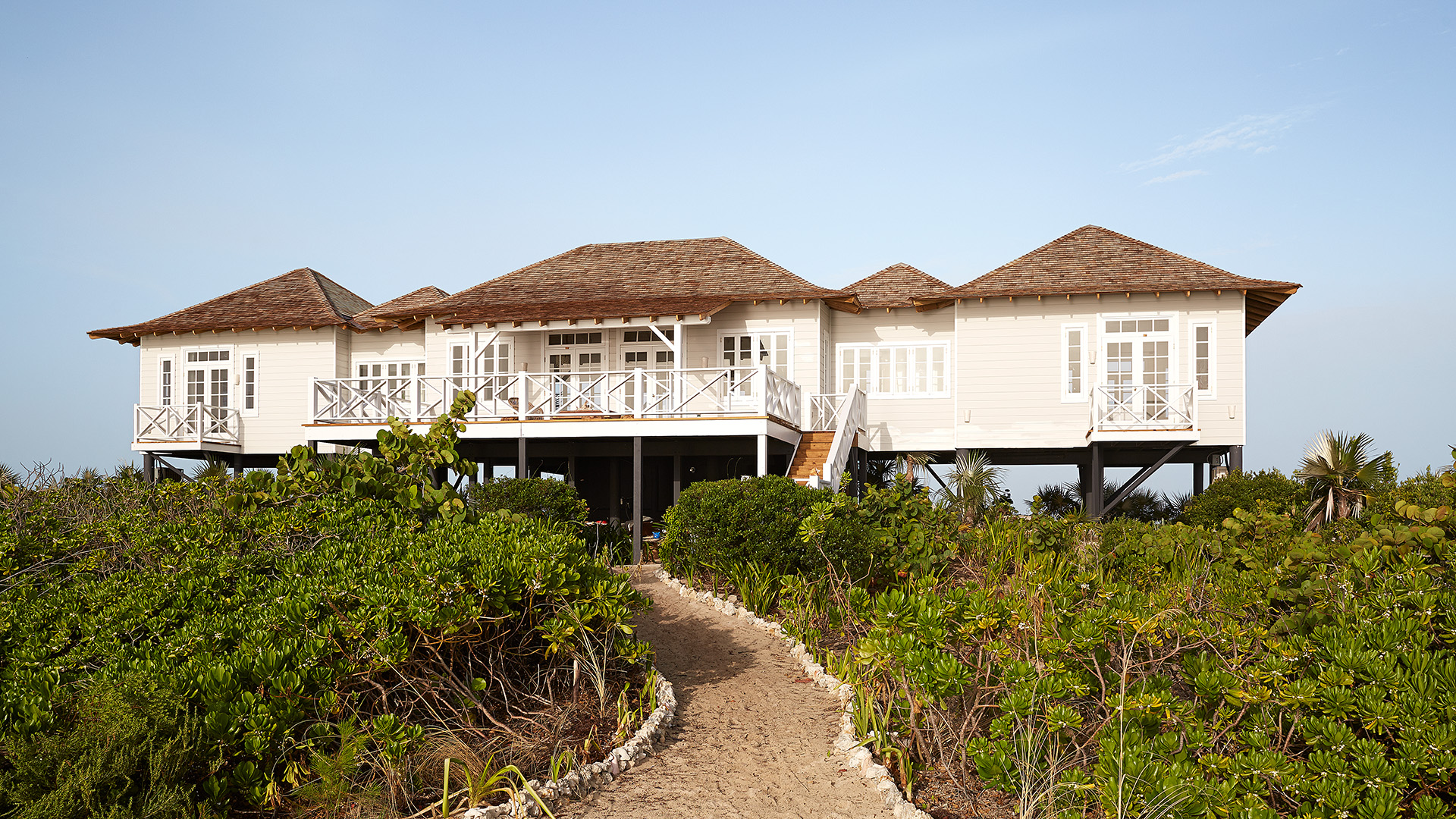 a house with a walkway and bushes