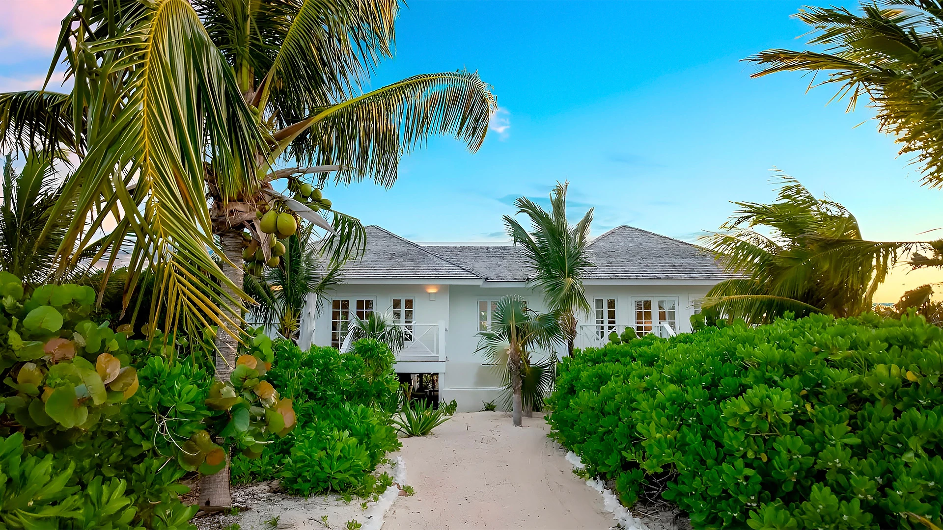 a house with a walkway and bushes