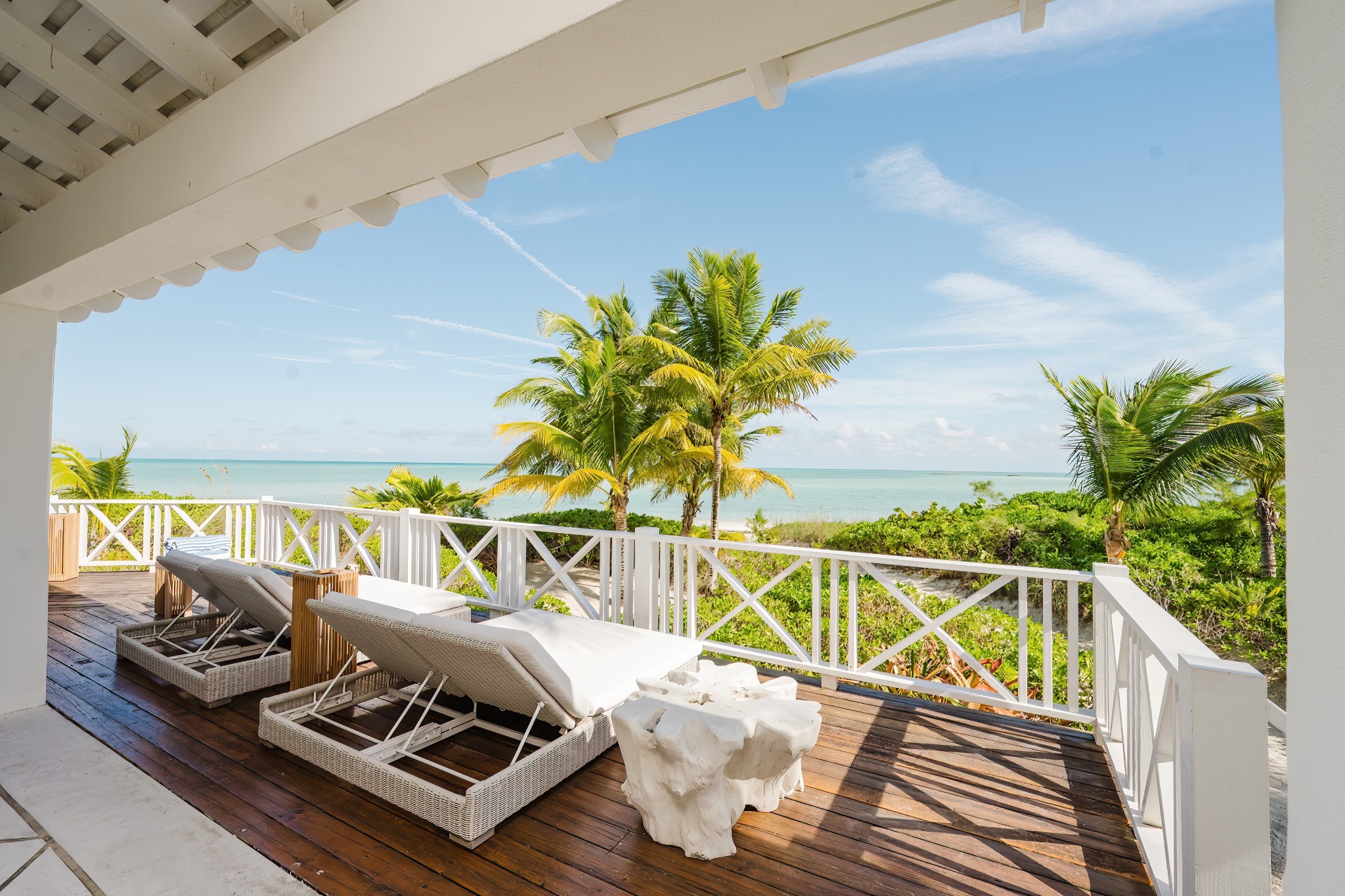 a deck with chairs and a view of the ocean