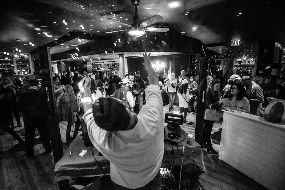 a man dancing in a room with a crowd of people