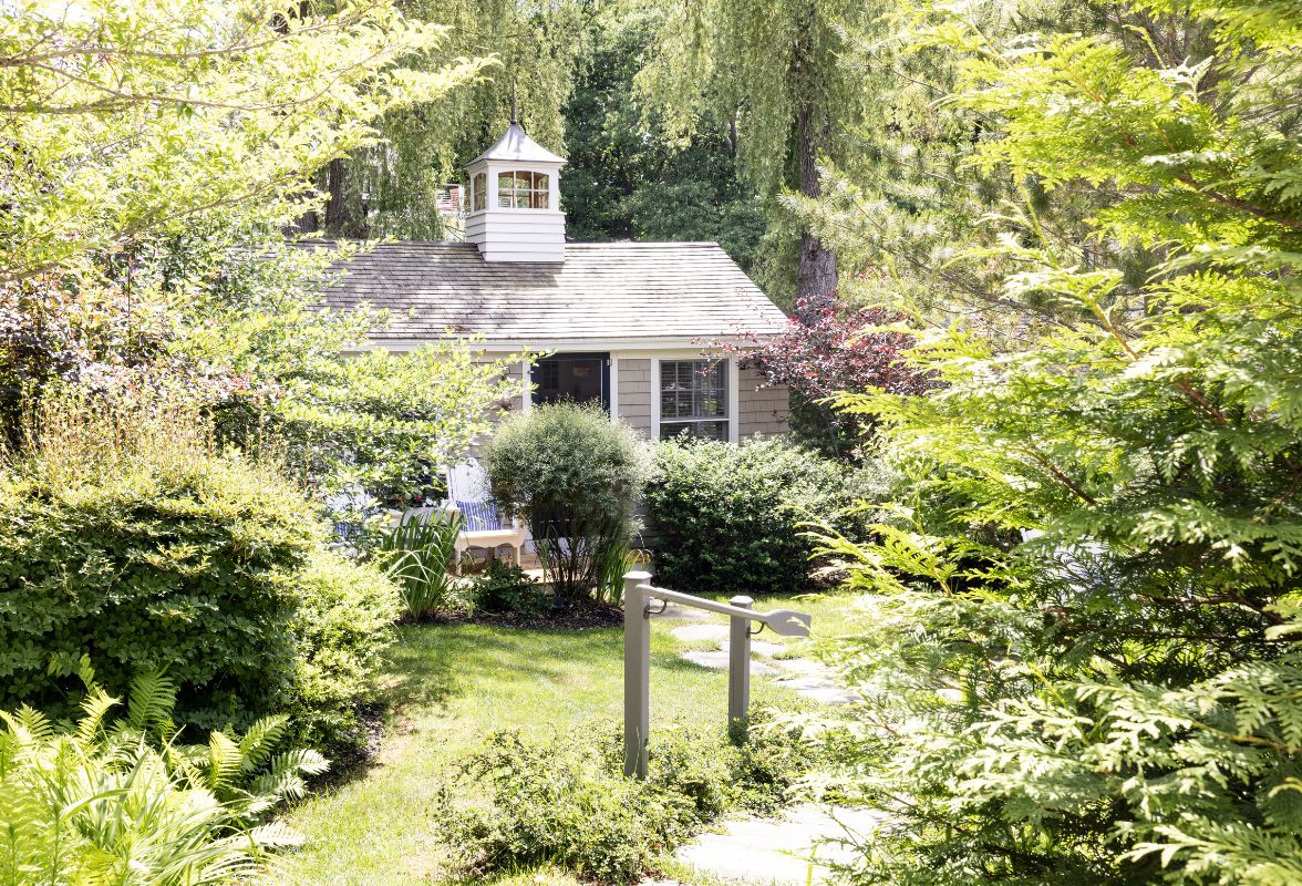 a house with a small white tower in the middle of a yard