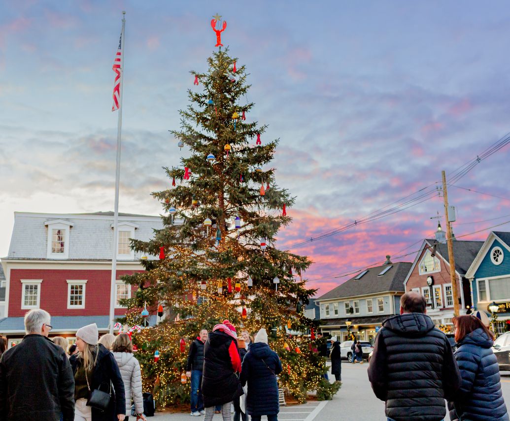 a group of people standing around a christmas tree