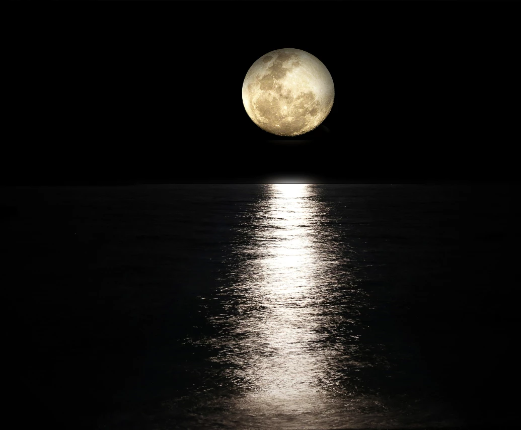 a moon over water at night