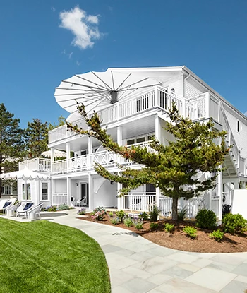 a white building with trees and lawn