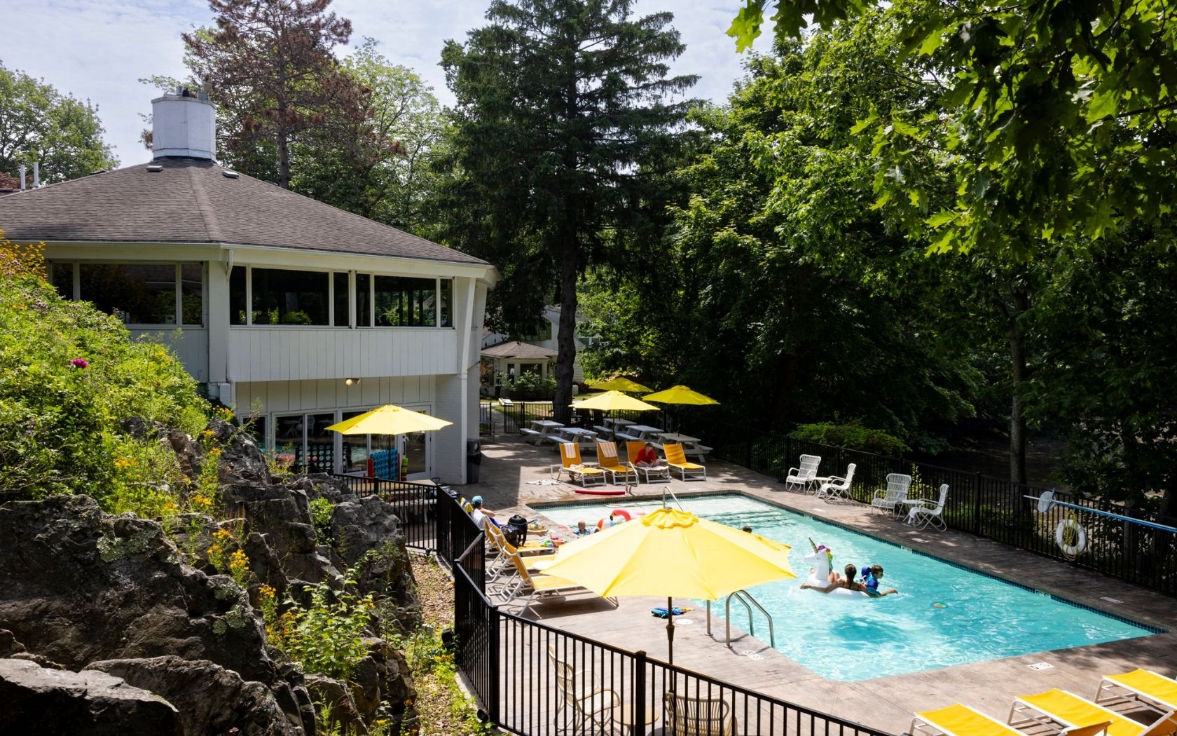 a pool with yellow umbrellas and a building