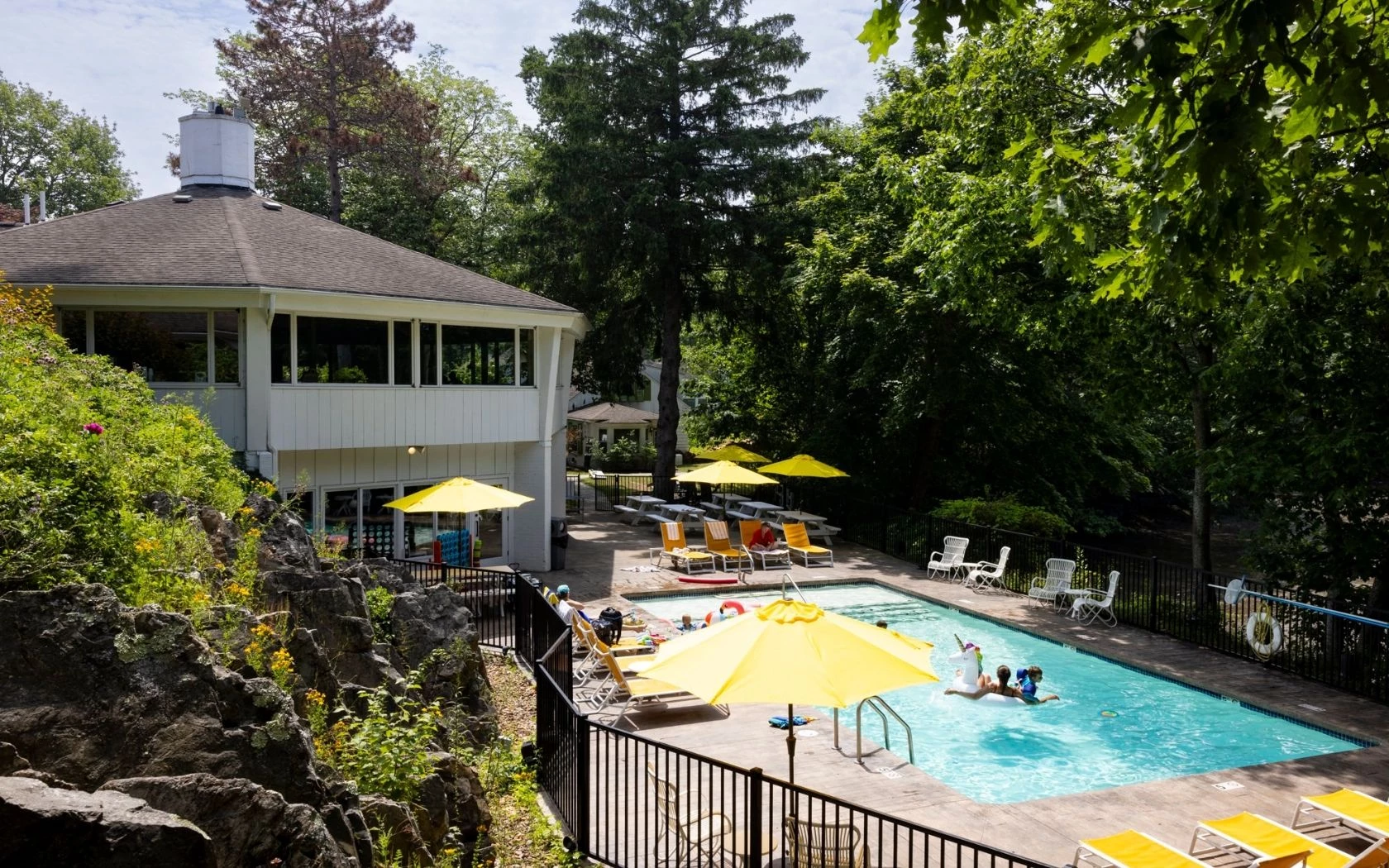 a pool with yellow umbrellas and a building
