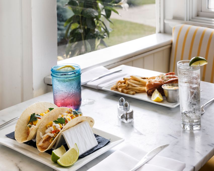 a plate of tacos and a drink on a table