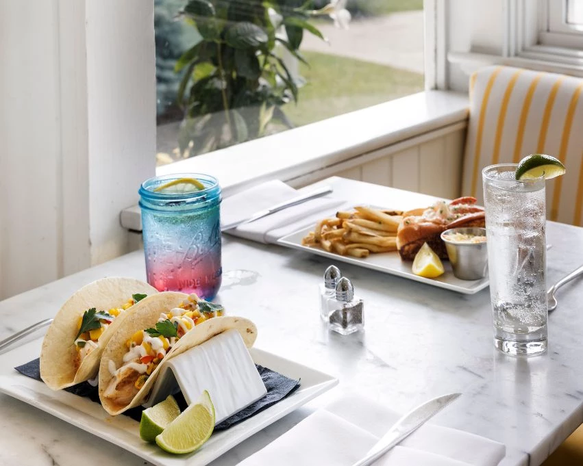 a plate of tacos and a drink on a table
