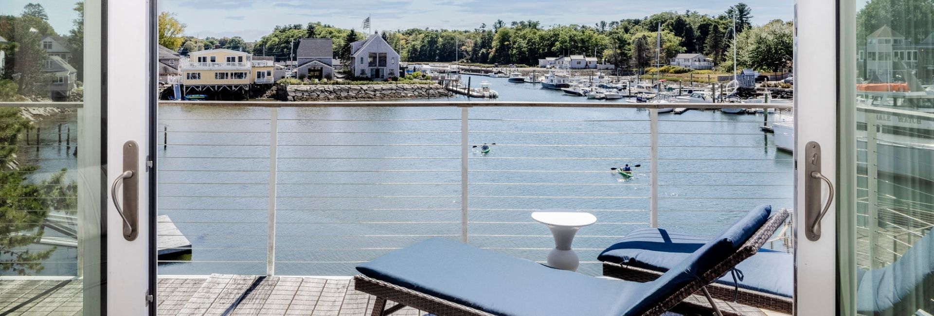 a deck with a chair and a table overlooking a body of water