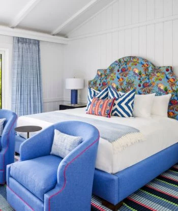 a bed with a blue headboard and a blue chair