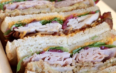three sandwiches cut in half on a tray