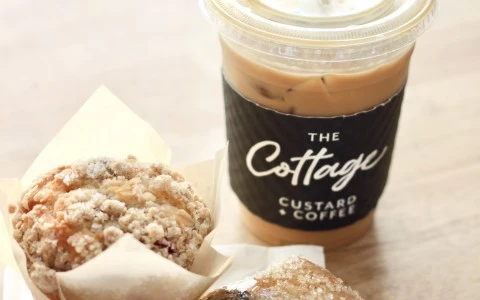 a cup of coffee next to a couple donuts