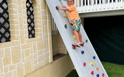 little boy climbing a mini rock wall