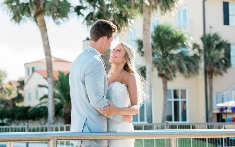 bride and groom looking into each others eyes posed outside of the venue along a low fence