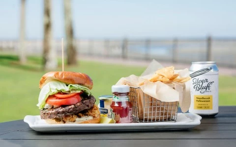 burger meal with a can and tomato sauce on the side