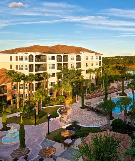 a building with a pool and trees in front of it