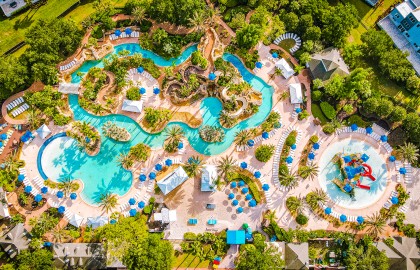 an aerial view of a resort with a pool and trees
